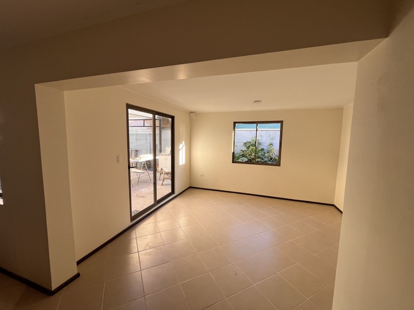 Living ampliado con piso cerámico en vivienda de Villa Bicentenario, Talca