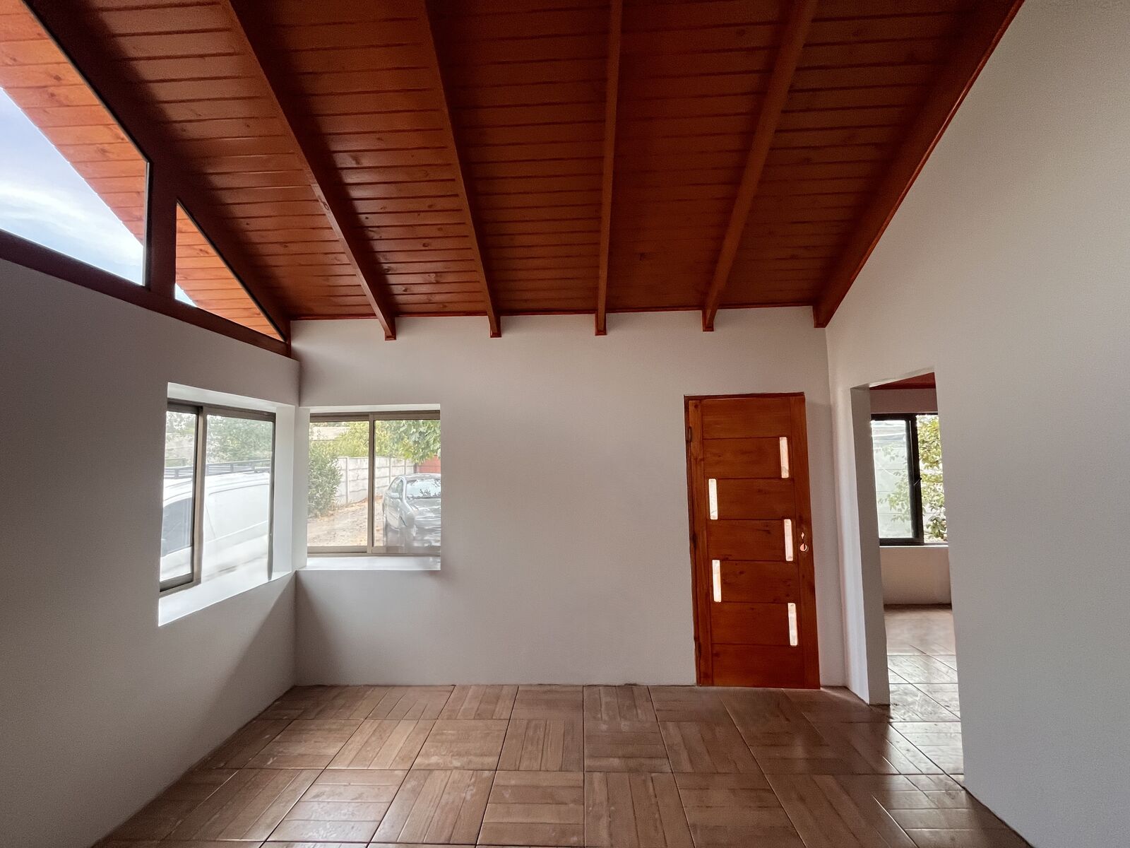 Vivienda de 97 m² construida por GHM Civil en Talca — living-comedor con cielo machihembrado y vigas a la vista