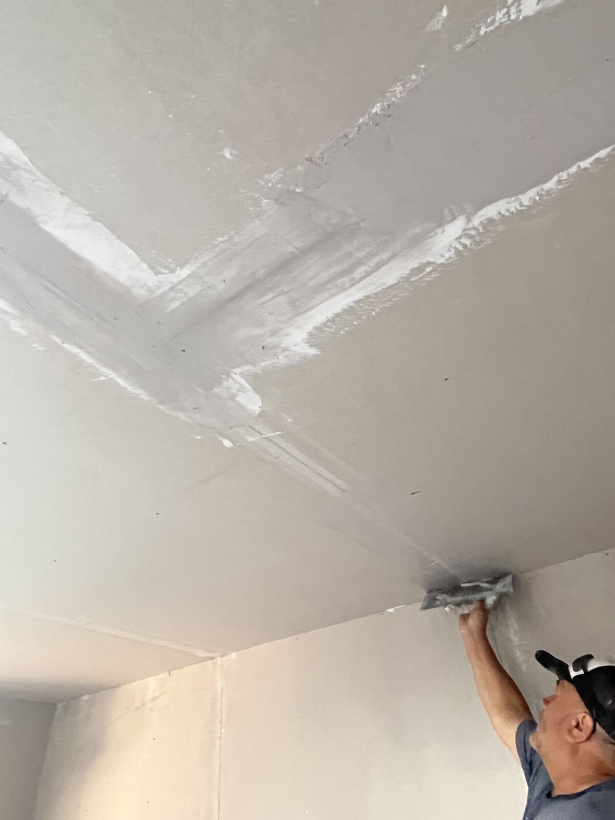 Maestro empastando cielo en obra de ampliación en Talca